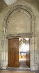 <p>Toegangsdeur van de kerk in het zuidportaal. Boven de deur is op het kalf het jaartal 1484 aangebracht. Onduidelijk is waar dit jaartal betrekking op heeft. Aangenomen wordt dat in dat jaar de kerk voltooid werd, maar een verwijzing naar de bouw van het portaal en/of het aanbrengen van deze toegang behoort ook tot de mogelijkheden. In dat geval moet het gotische schip eerder opgeleverd zijn. </p>
